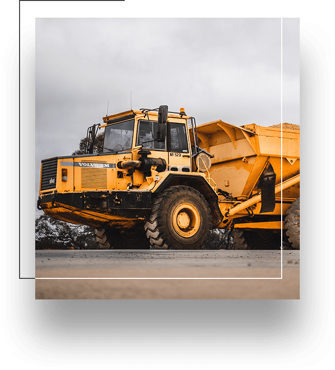 A yellow dump truck is parked on the side of the road.